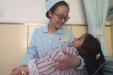 市口腔医院颌面外科病房护士长张玮给住院的口腔疾病患儿母亲般的呵护