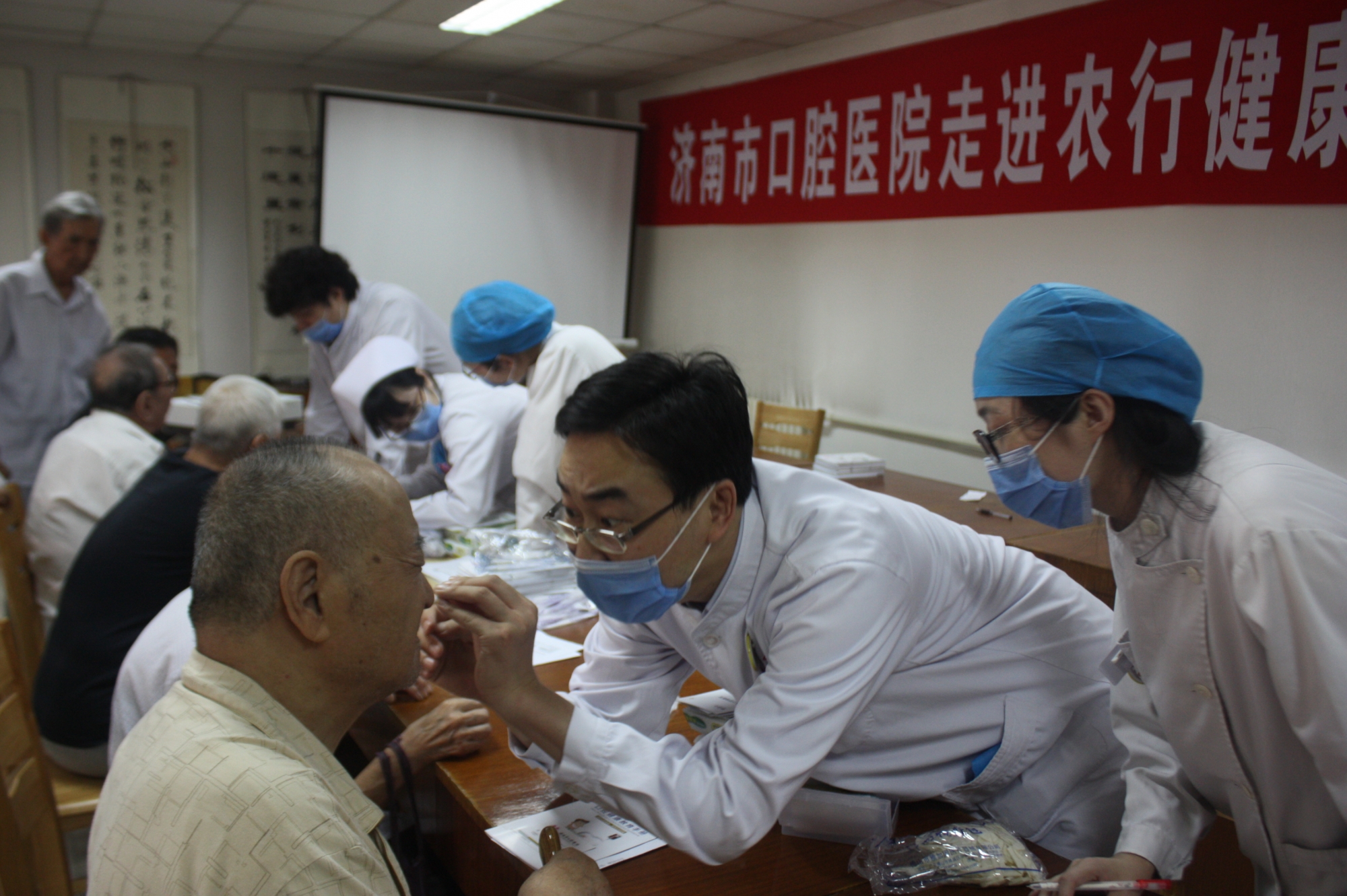 口腔医生在为老人们进行义务口腔健康检查